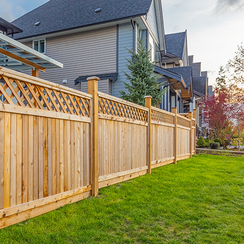 Residential wooden fence manicured lawn